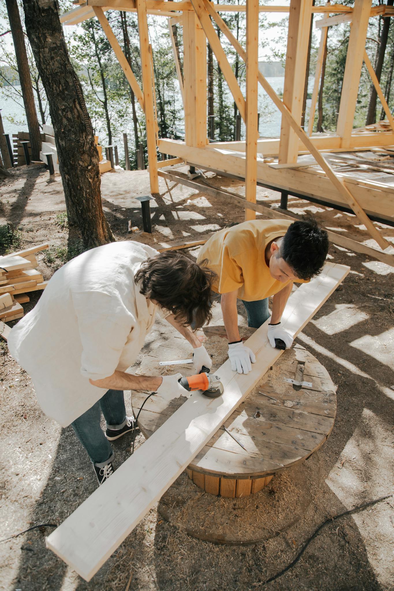 Men Using a Grinder on a Wood Plank